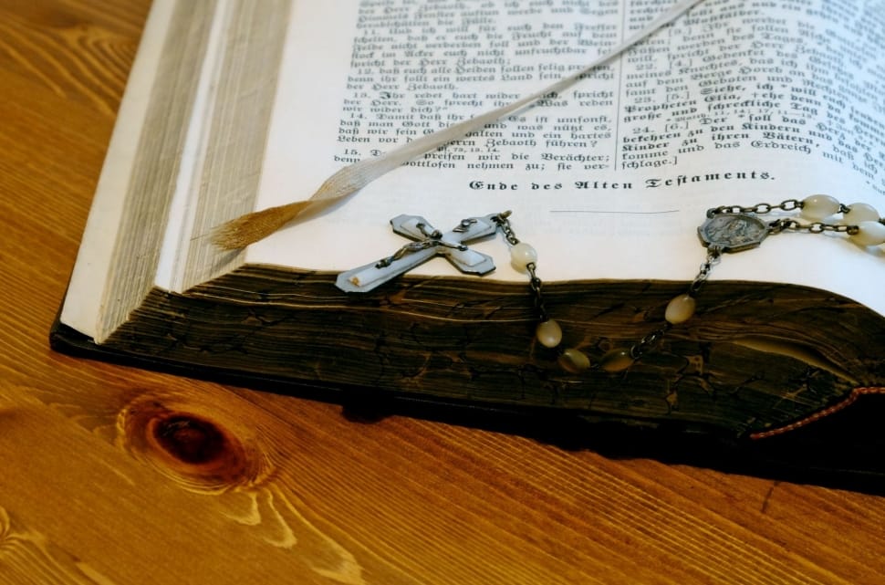 opened bible on brown wooden surface preview