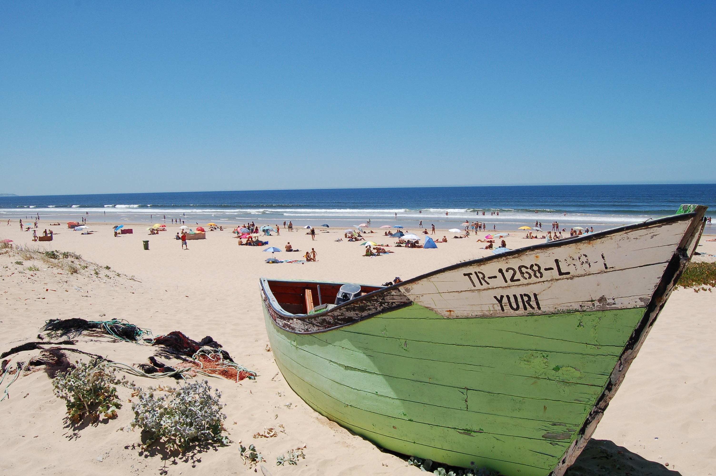 green and white wooden boat in the sand pictuure during day time