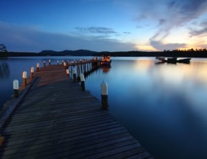 brown wooden dock under blue sky during sunset thumbnail