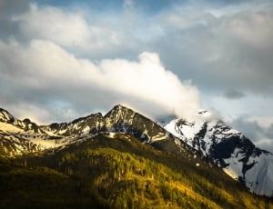snowed mountain under blue and white cloudy sky phot thumbnail