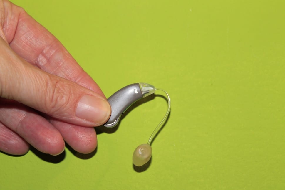 person holding gray earpiece preview
