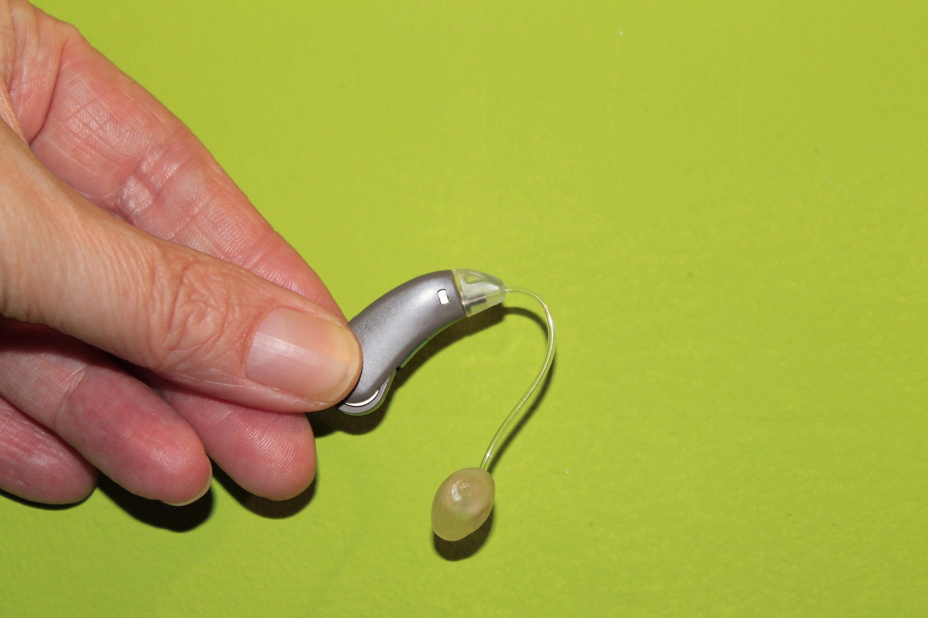 person holding gray earpiece