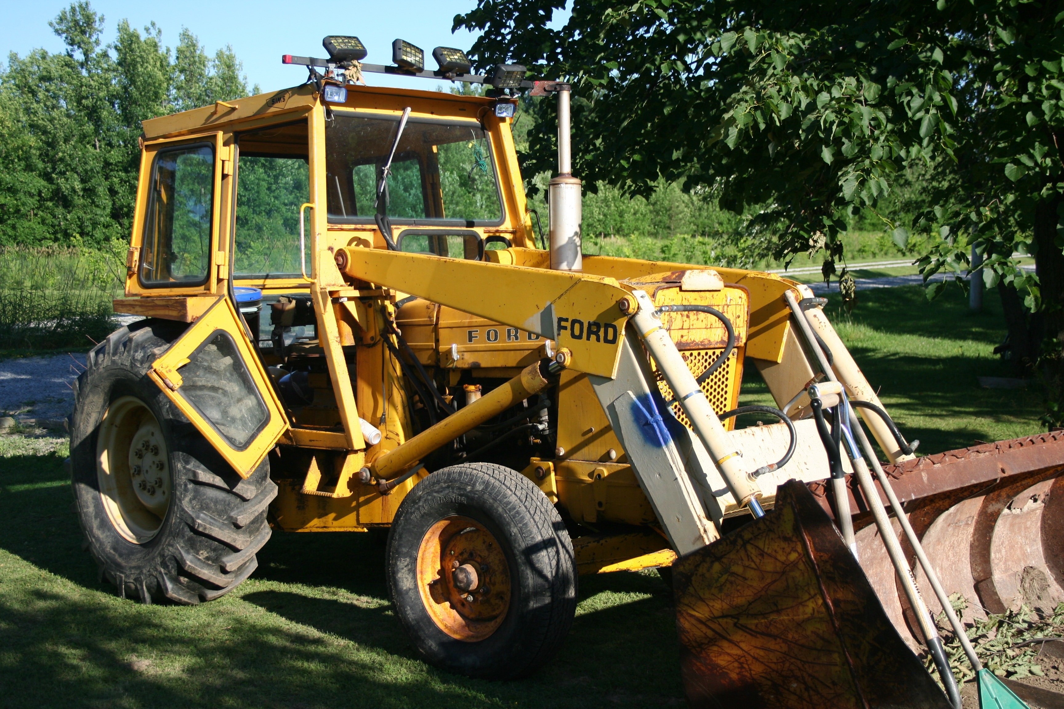yellow front loader near tree
