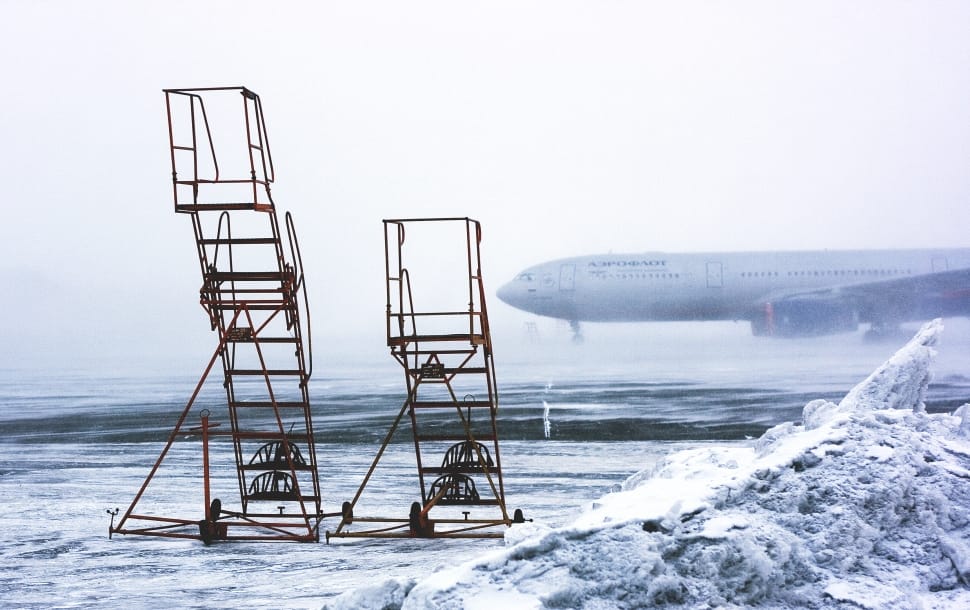two brown steel wheeled airplane stairs on snow field during daytime preview