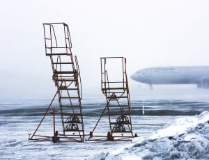 two brown steel wheeled airplane stairs on snow field during daytime thumbnail