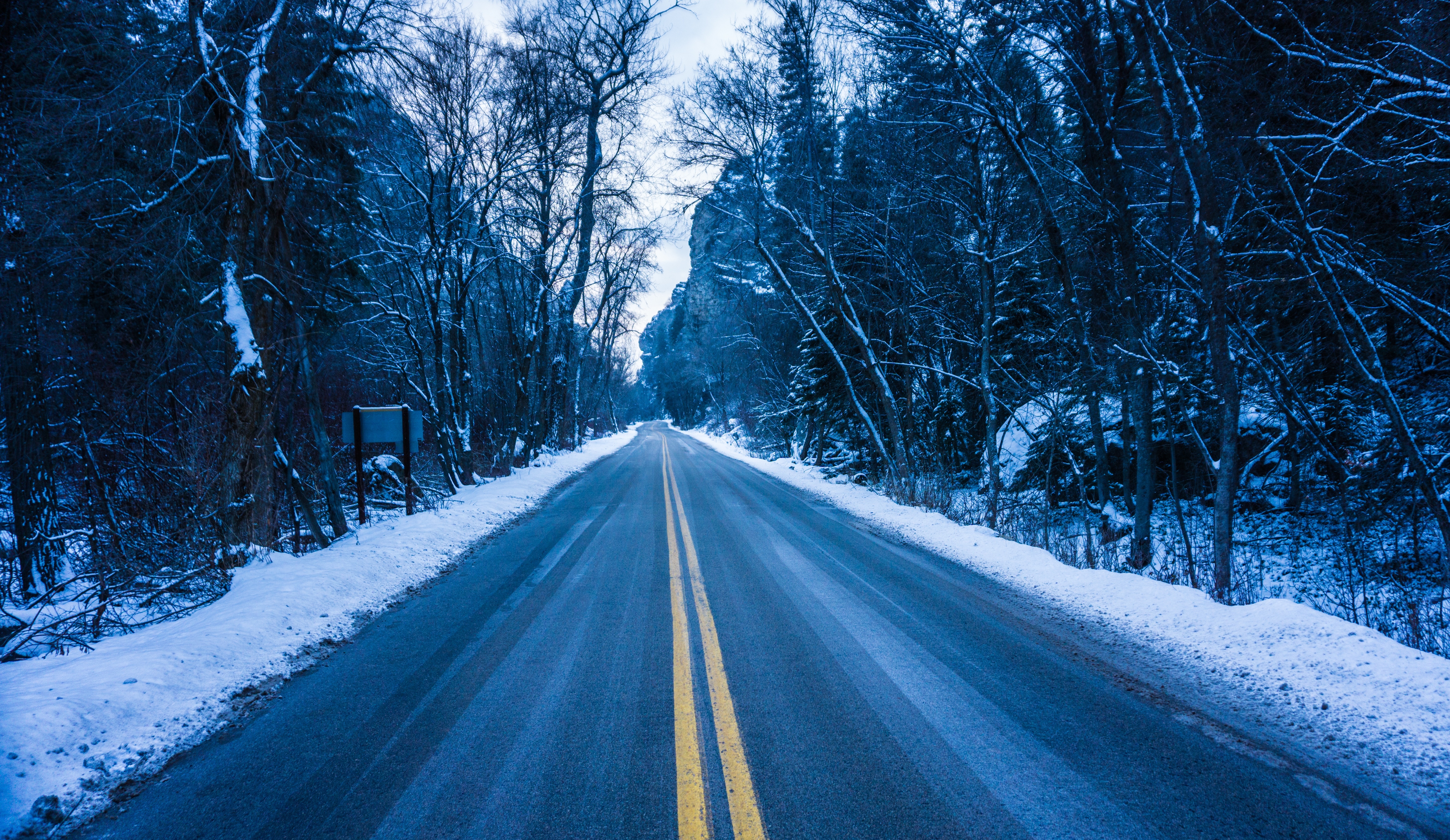 empty road with snow on the sides at daytime
