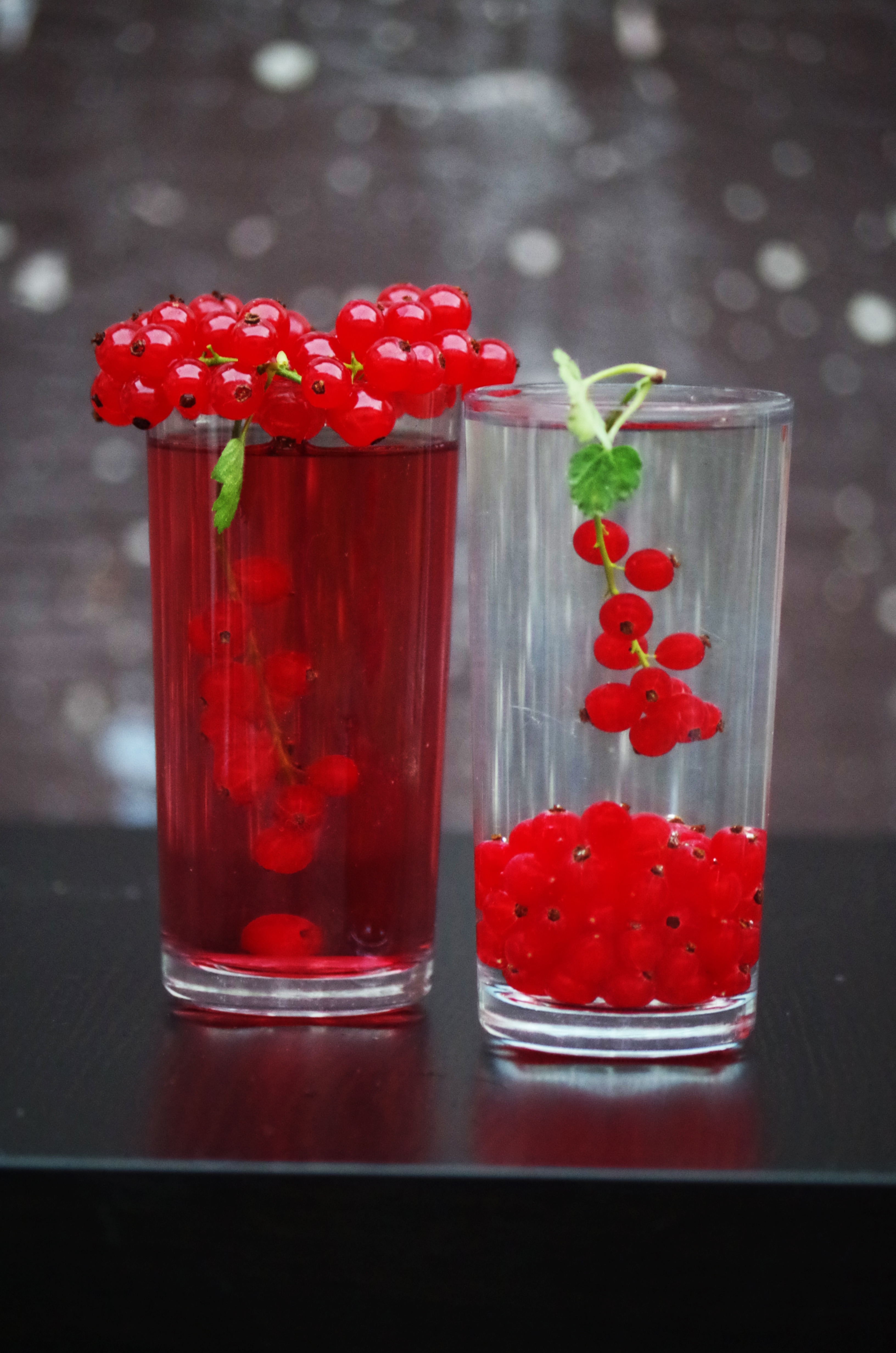 red round fruits in side clear drinking glass with liquids inside