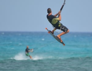 selective focus photo of man windsurfing on beach thumbnail
