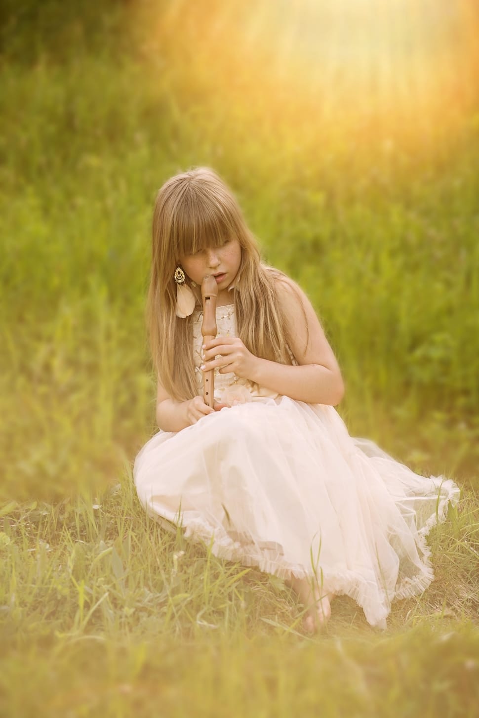 girl's wearing white sleeveless dress using brown clarinet under sunny day during daytime preview