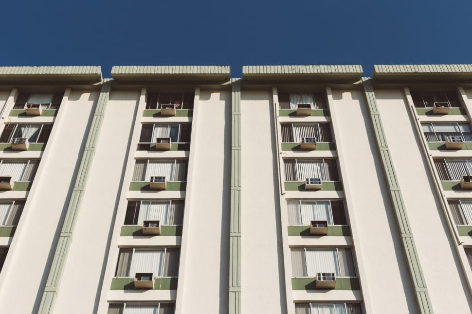 low angle photography of a white and green high rise building during a sunny weather preview