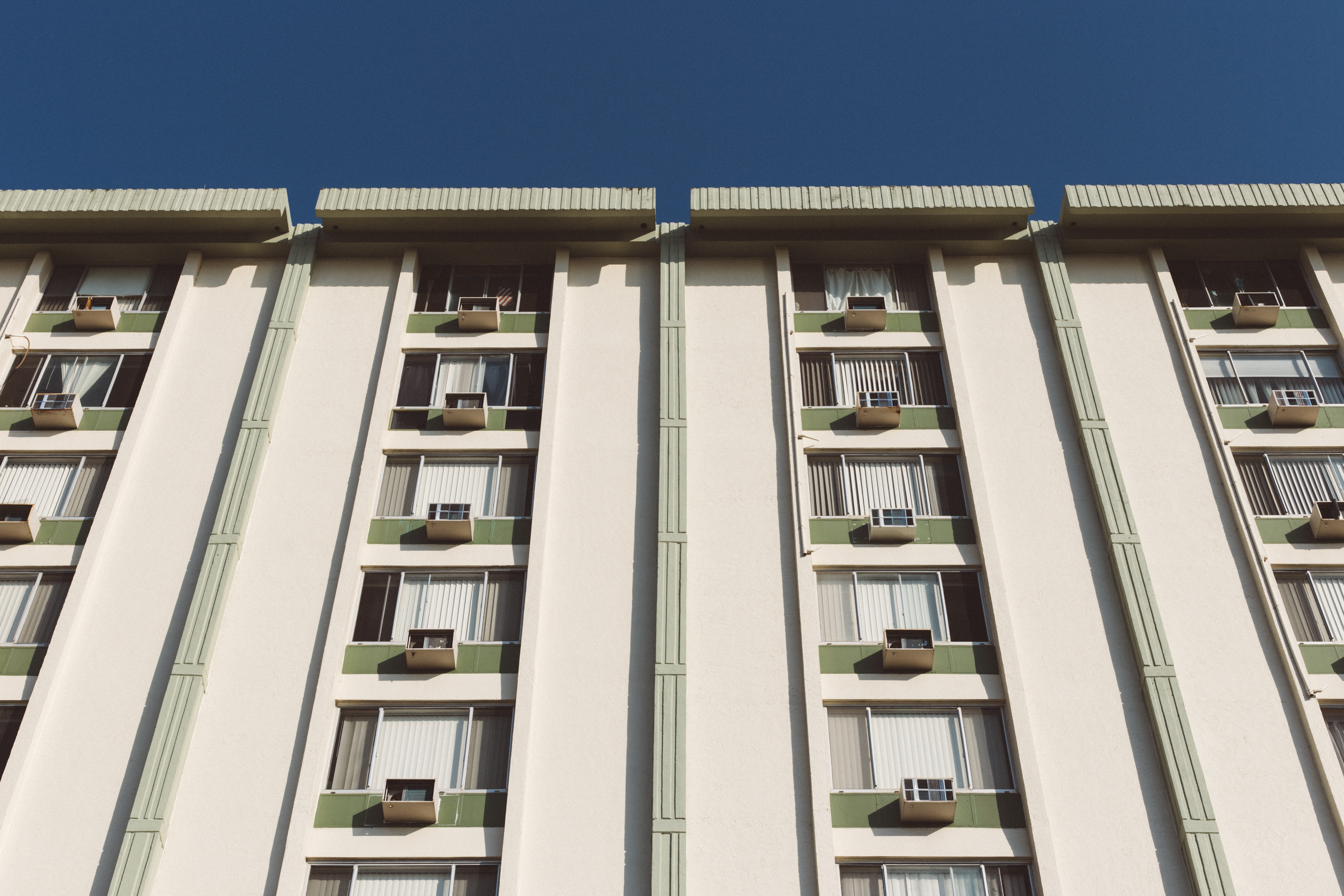 low angle photography of a white and green high rise building during a sunny weather