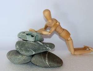 brown wooden puppet and gray stone fragments thumbnail