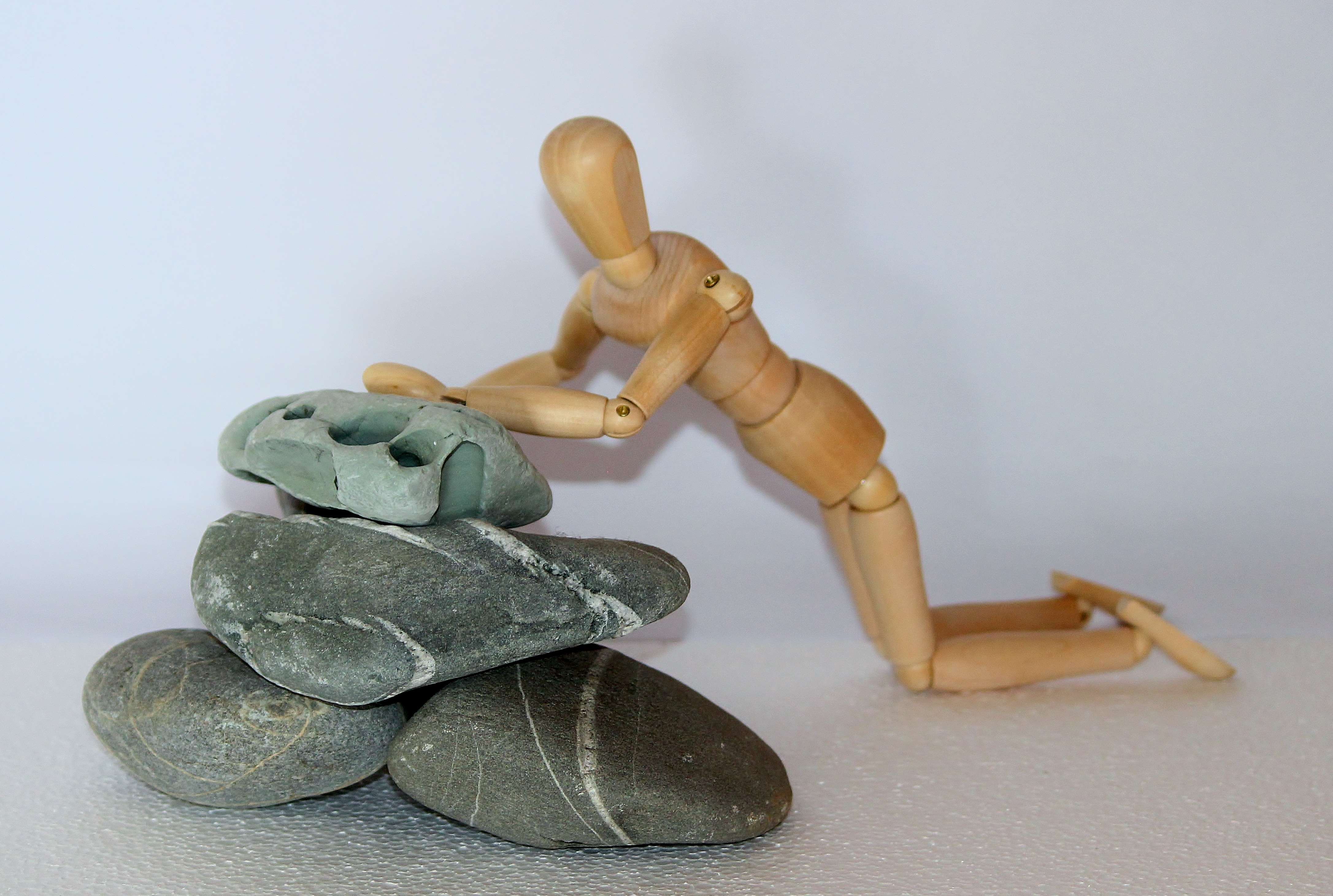 brown wooden puppet and gray stone fragments