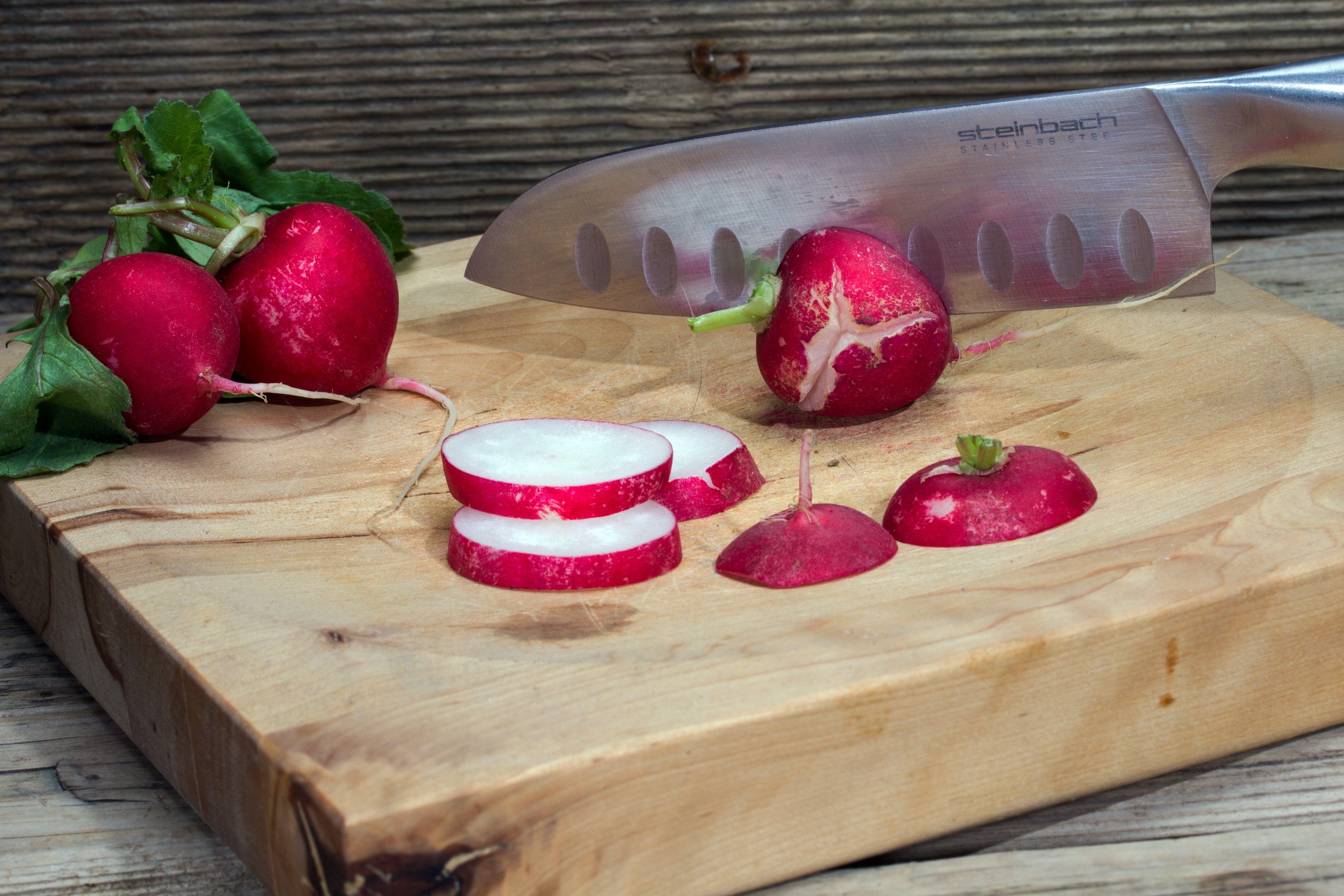 red fruit sliced on brown wooden cutting board with stainless steel kitchen knife