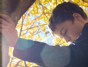 boy's grey jacket under on tree during daytime thumbnail