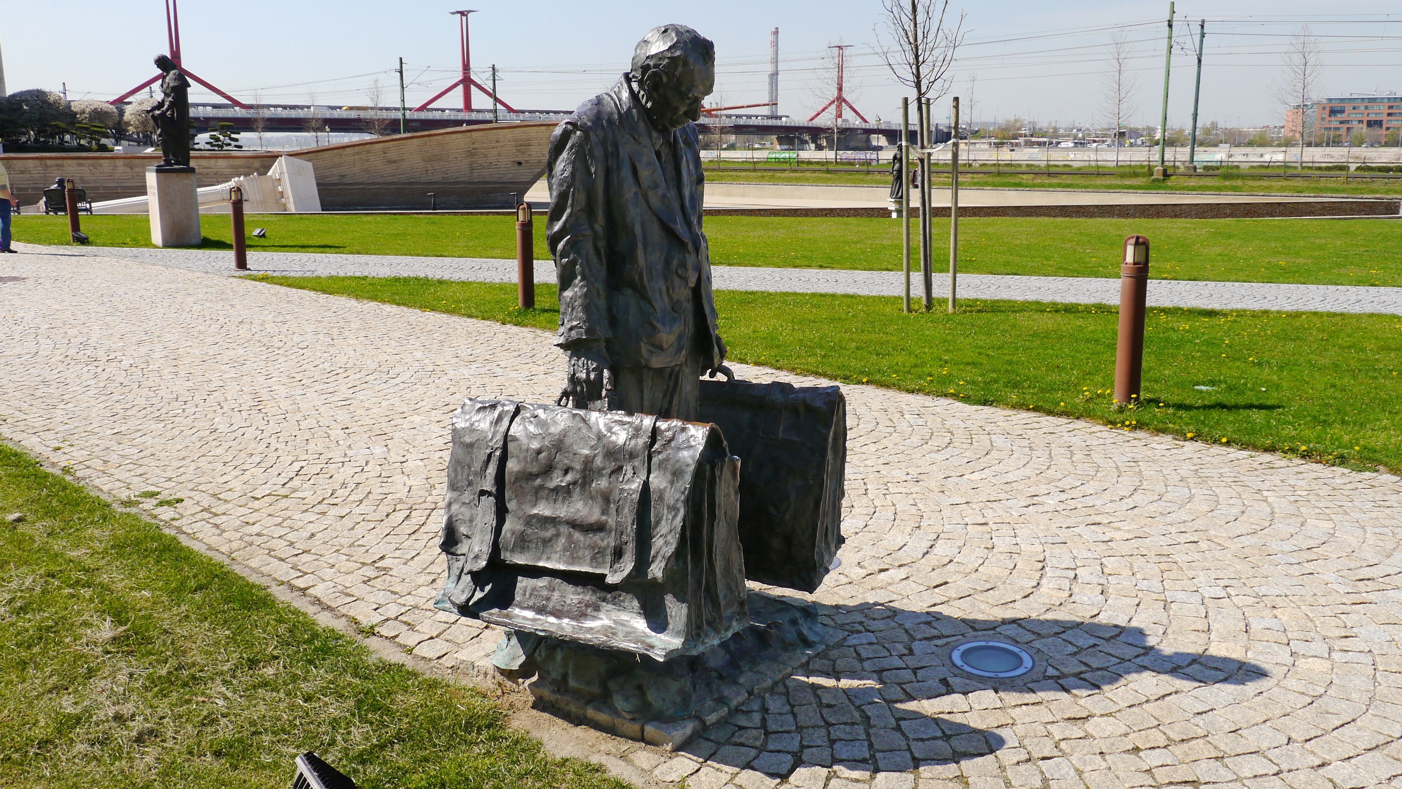 grey statue of man carrying two luggages