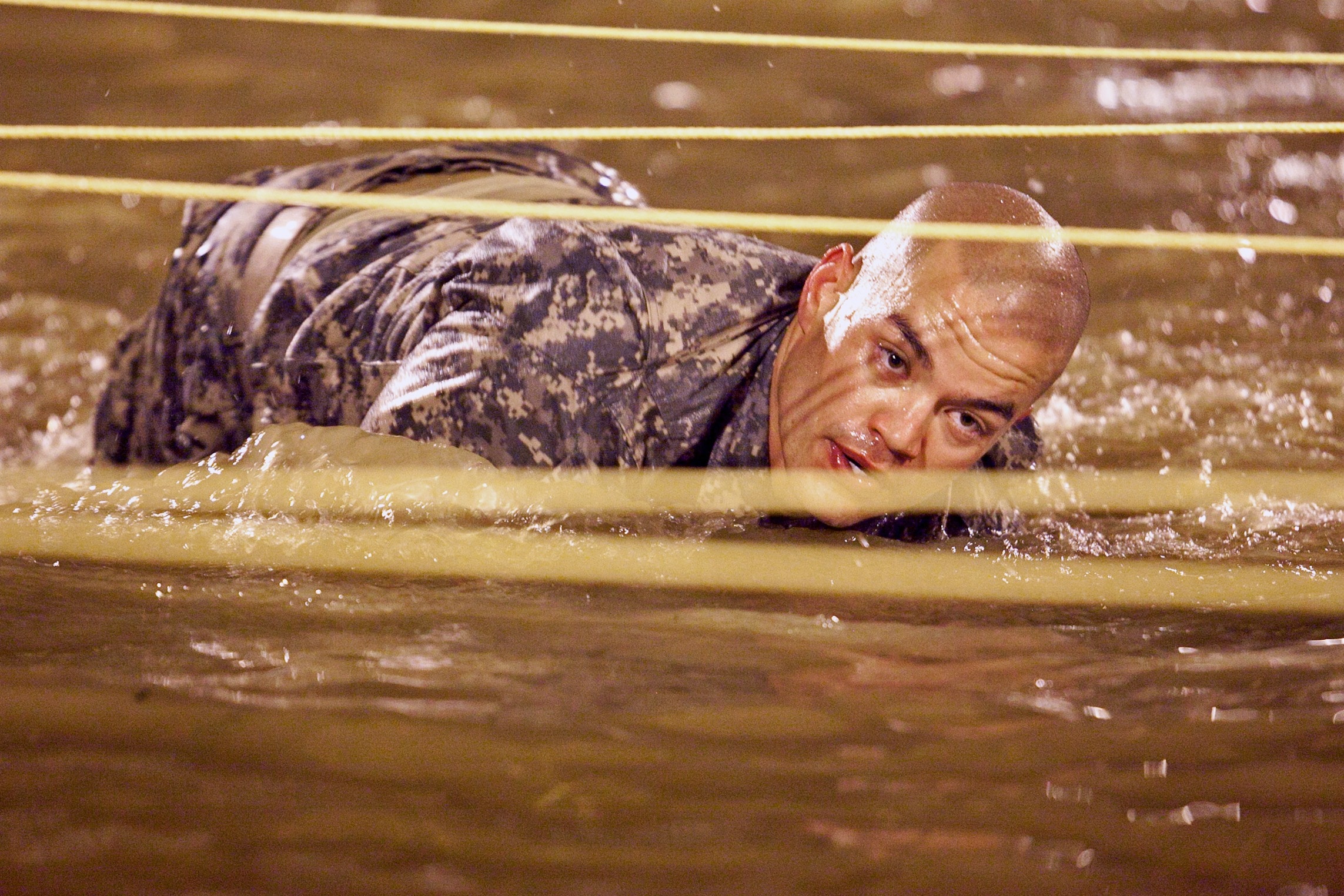 Military crawling in body of water