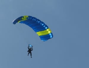 person in blue and yellow parachute thumbnail