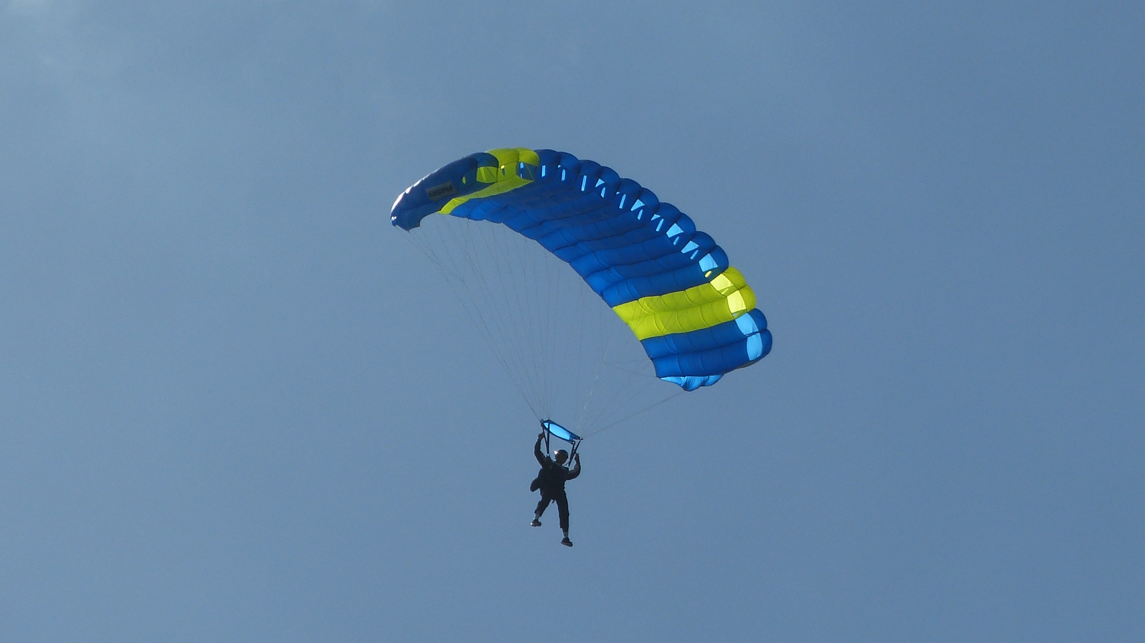 person in blue and yellow parachute