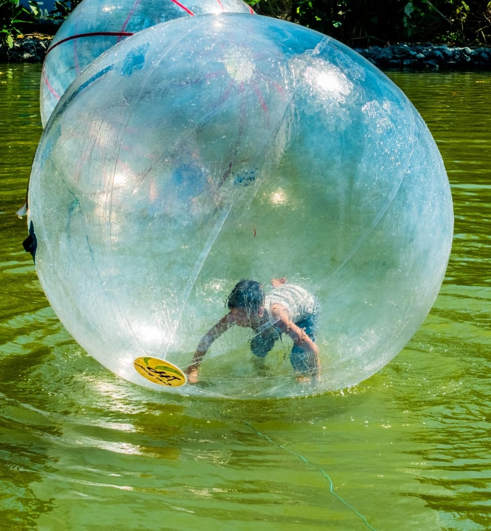 boy inside bubble on top of water photo during daytime preview