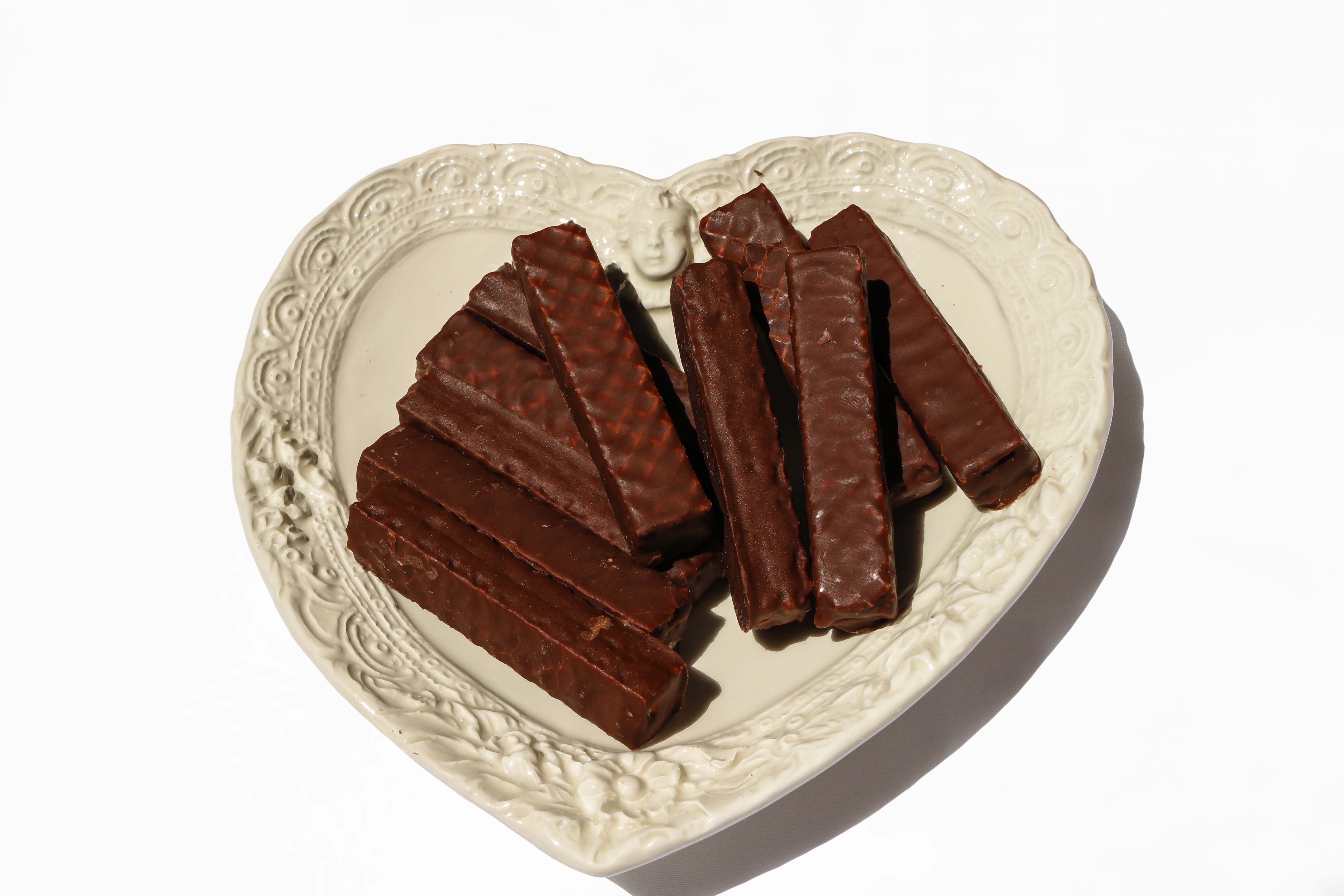 brown chocolate bar on white heart shaped plate
