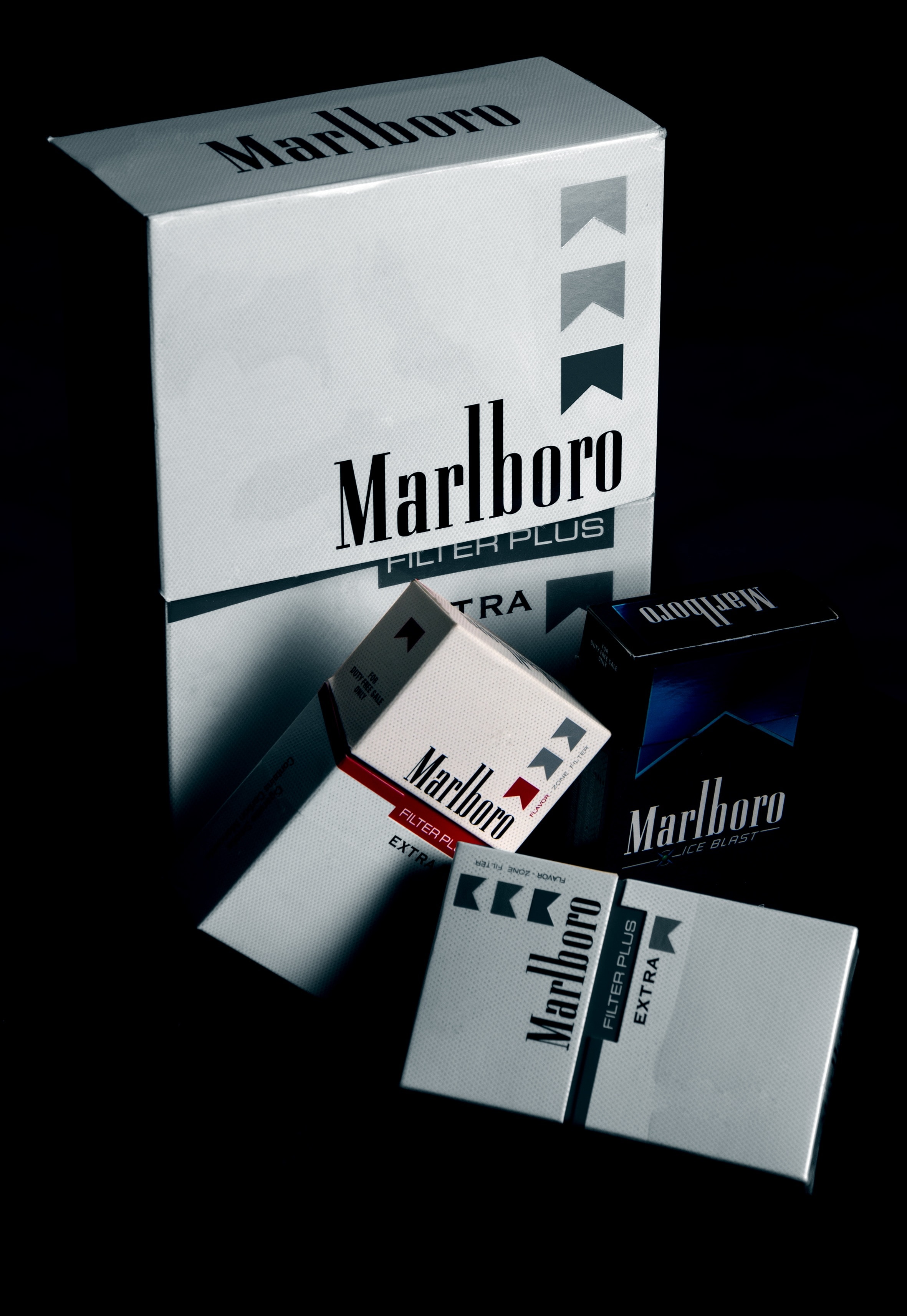 three black and white Marlboro flip top cigarette boxes