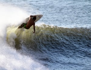 person in green bottoms surfing during daytime thumbnail