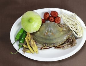 capture image of a raw crab with whole onions two green chillies thumbnail