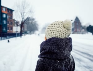 person wearing bobble cap standing in front of snowfield thumbnail