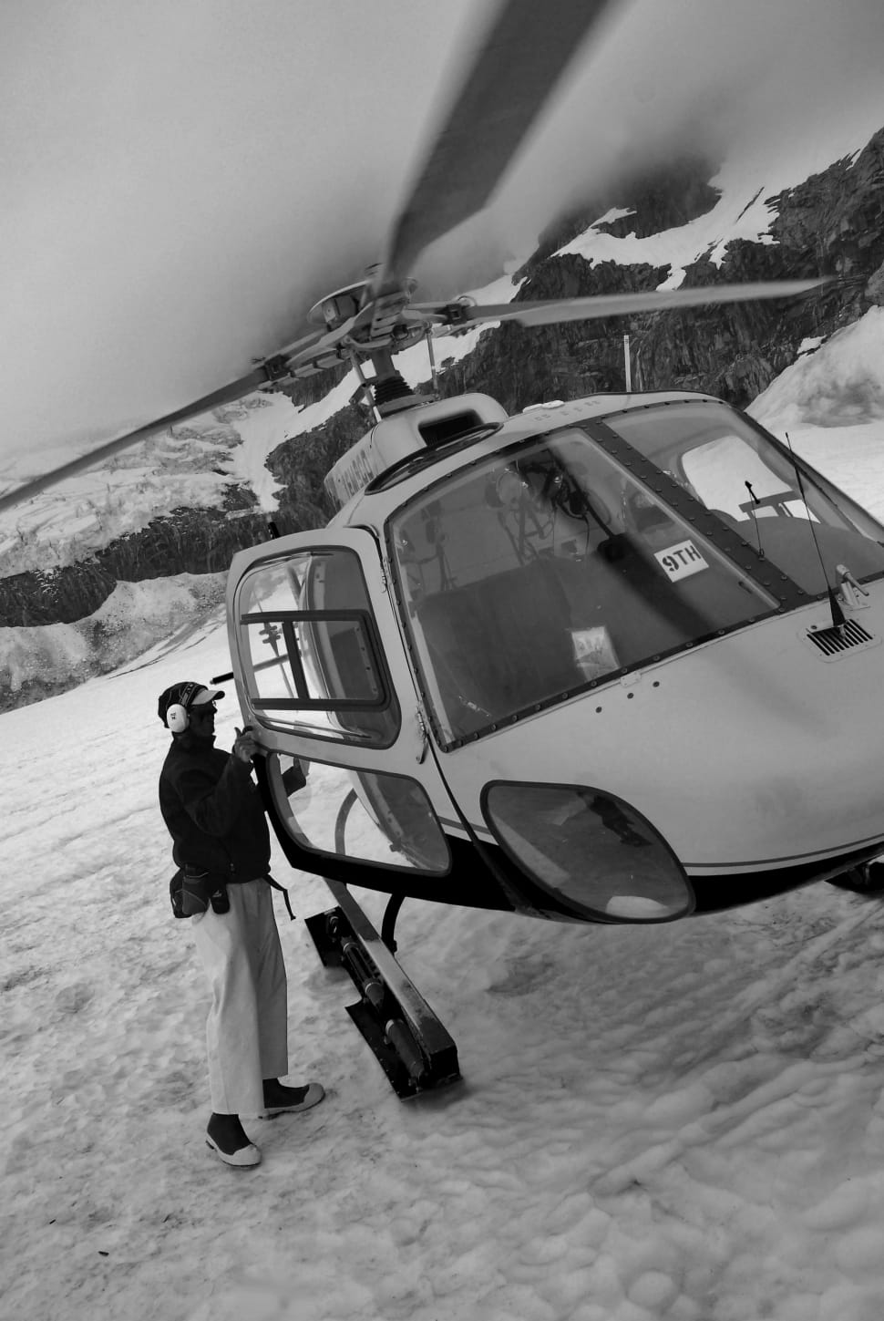 grayscale photography of man going in helicopter preview