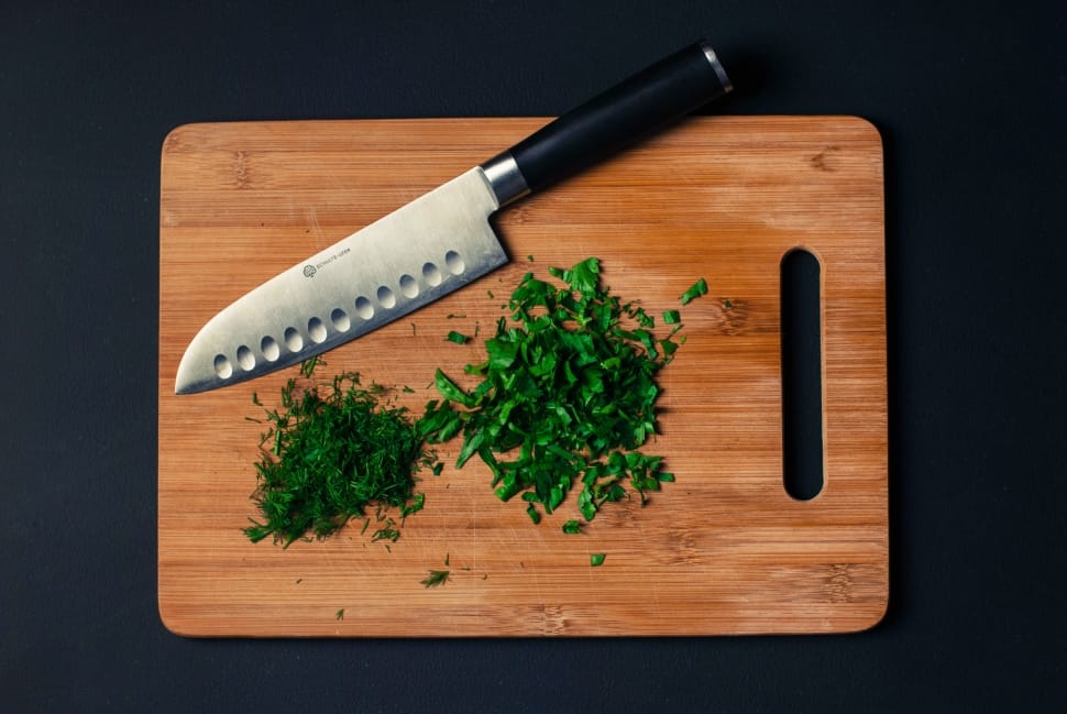 black handled knife and brown wooden chopping board preview