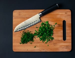 black handled knife and brown wooden chopping board thumbnail