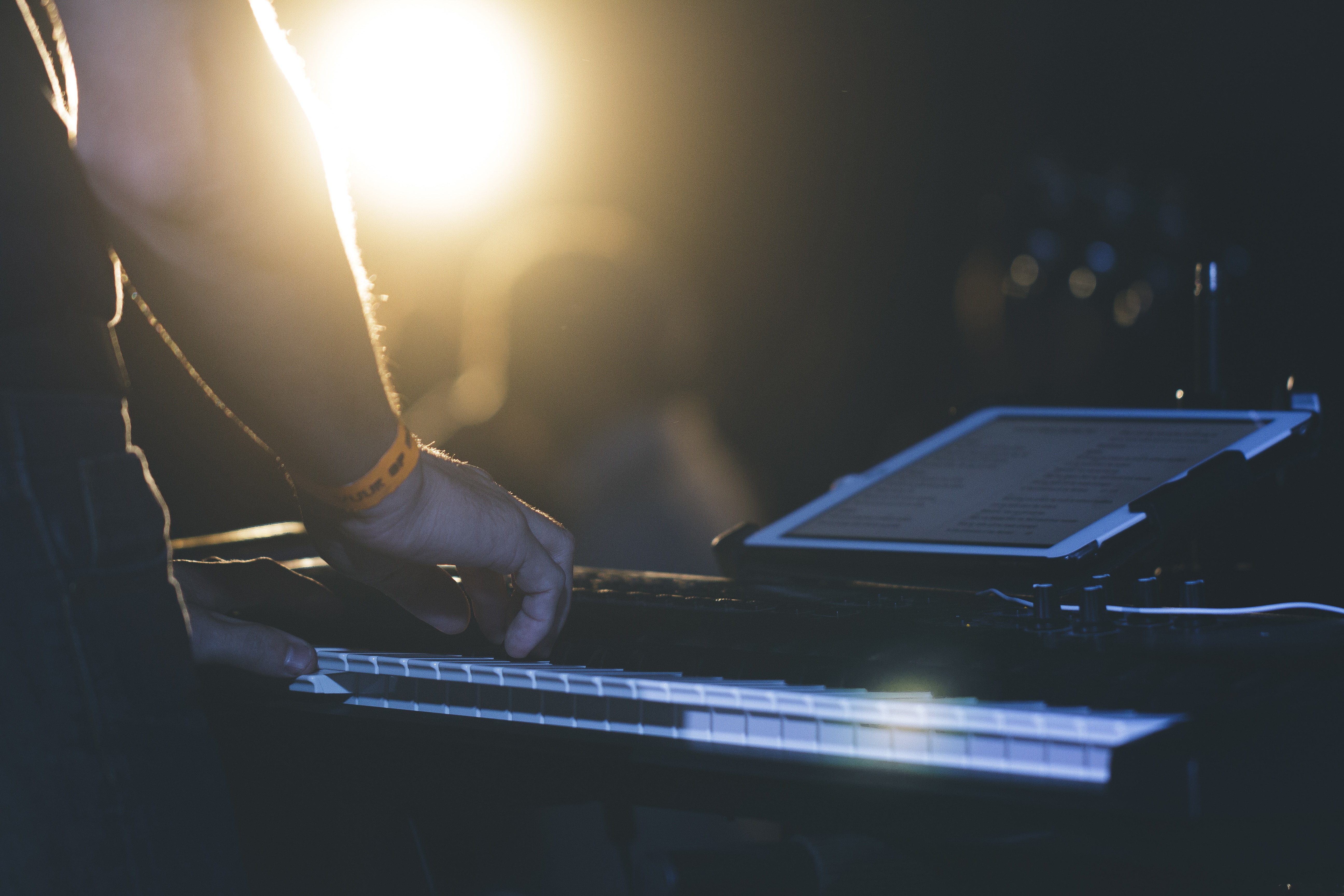 man in front of electric keyboard on stage
