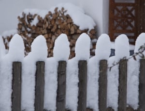 grey wooden fence covered with snow thumbnail