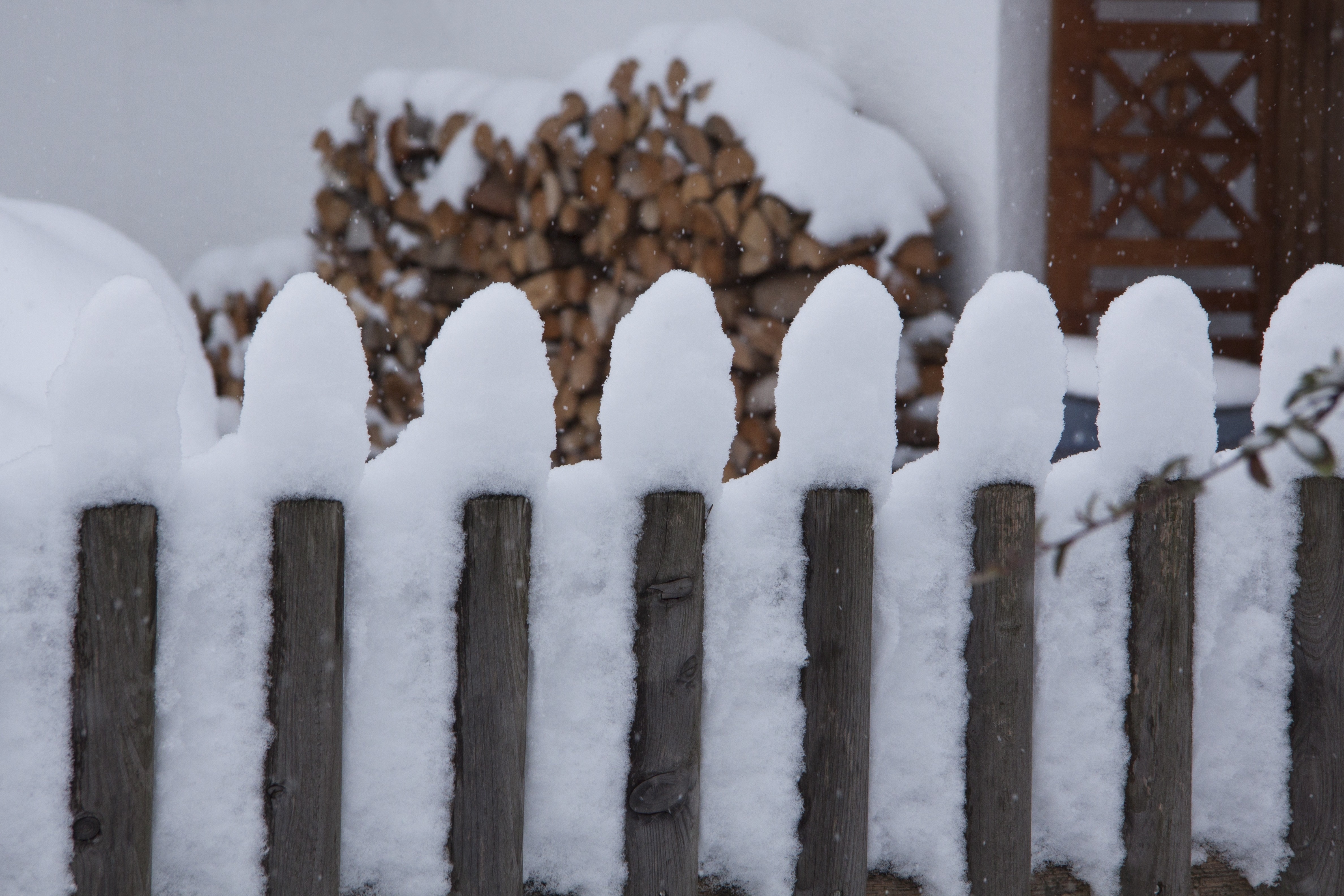 grey wooden fence covered with snow