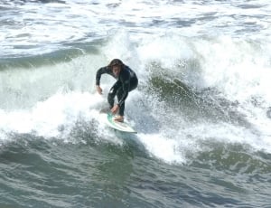 man riding on surfboard thumbnail
