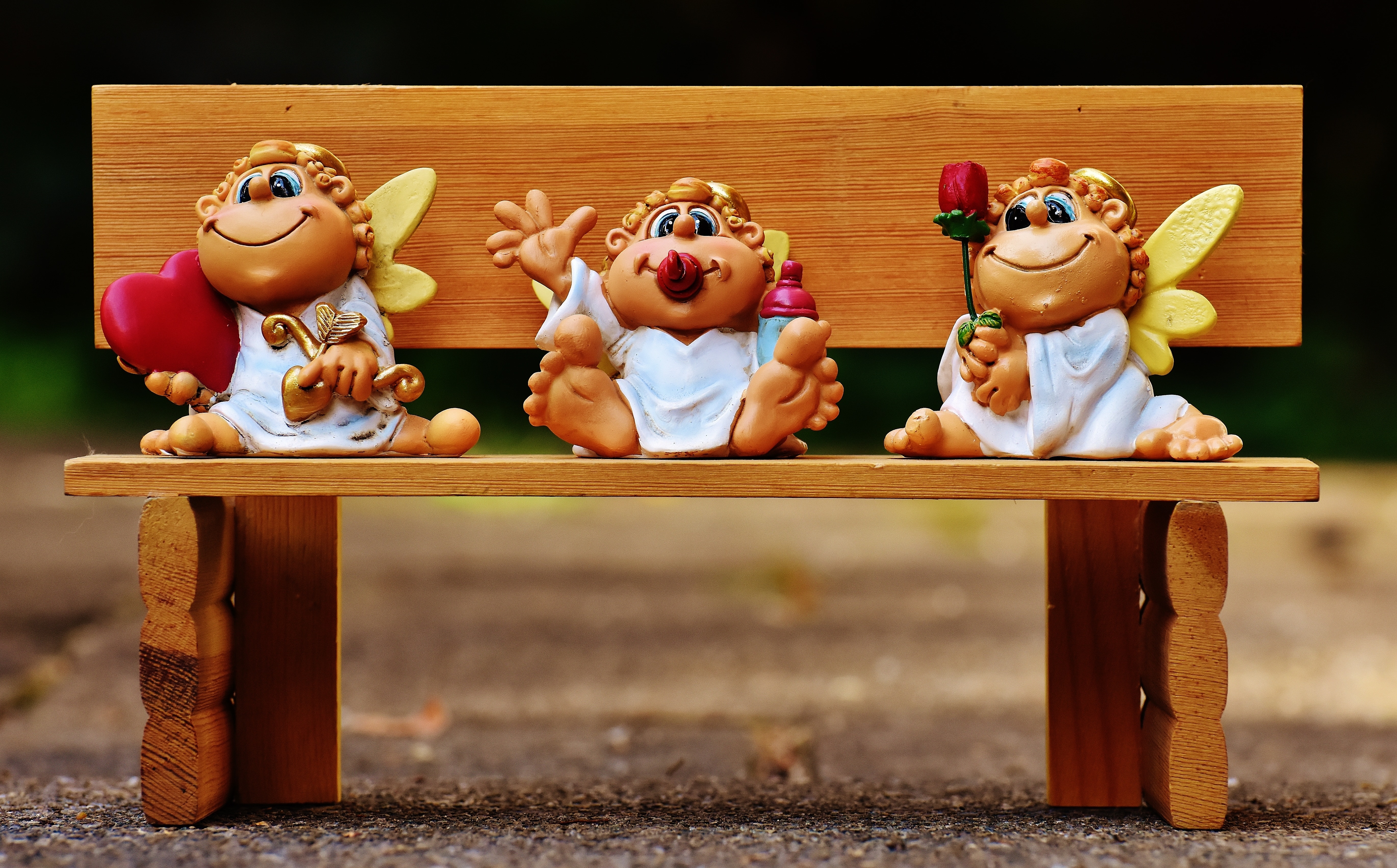 white and brown cherub sitting on bench figurines