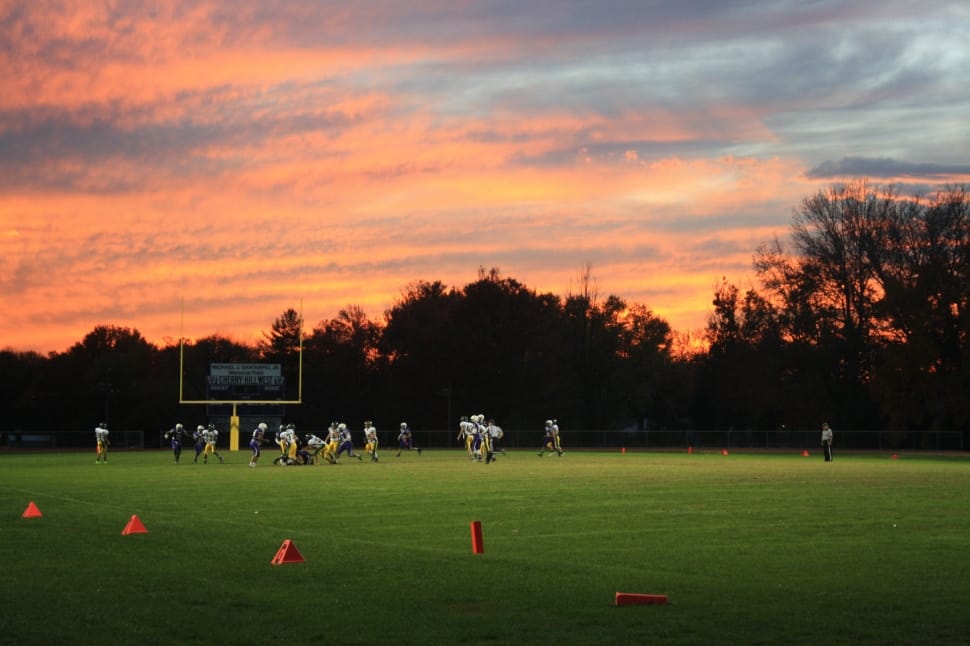 photography of football field with ongoing football game on sunsety preview