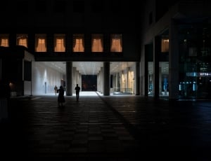 two persons near concrete building at night time thumbnail