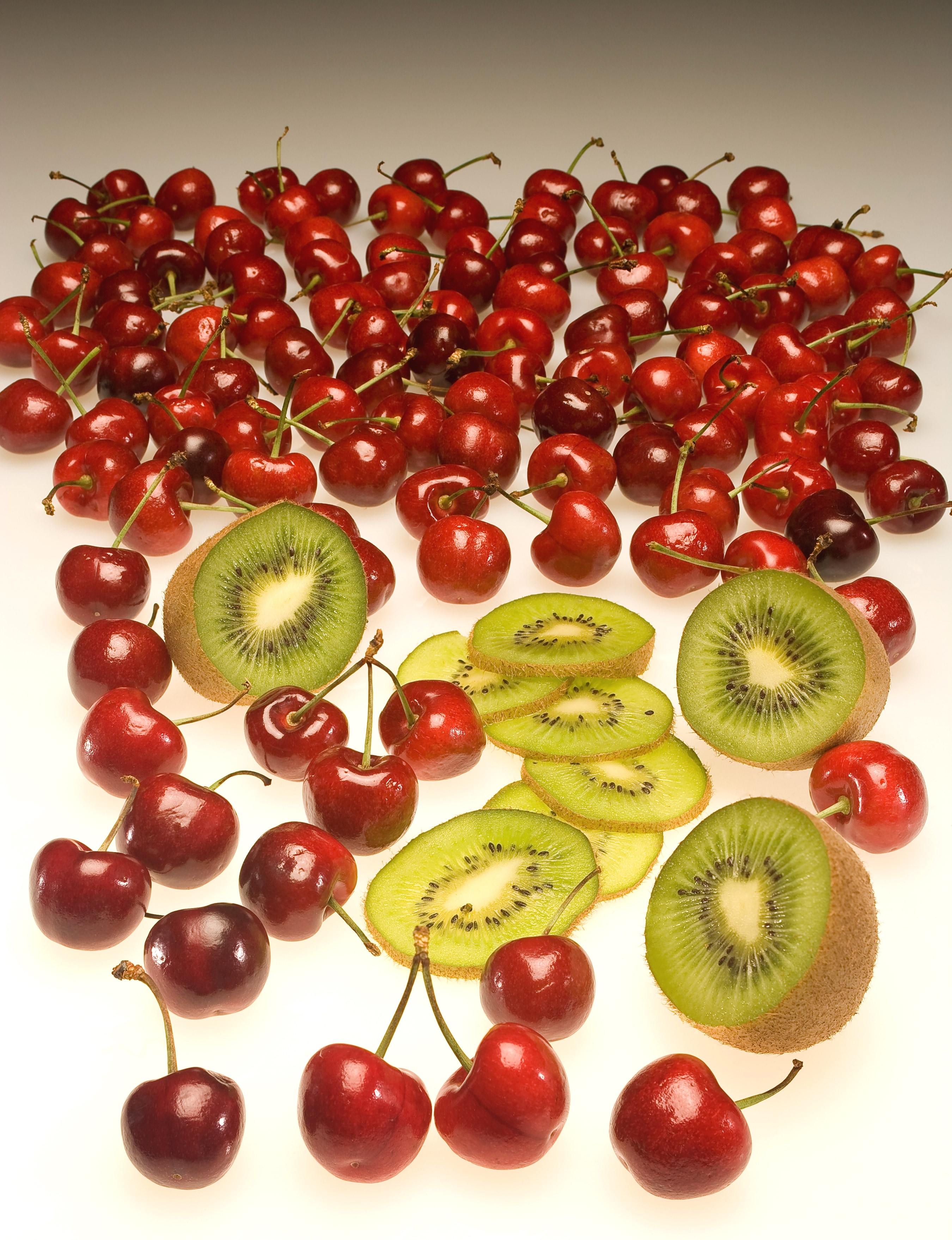 sliced kiwi fruits and red cherries