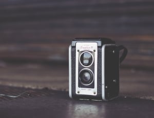 black and white camera on brown wooden top thumbnail