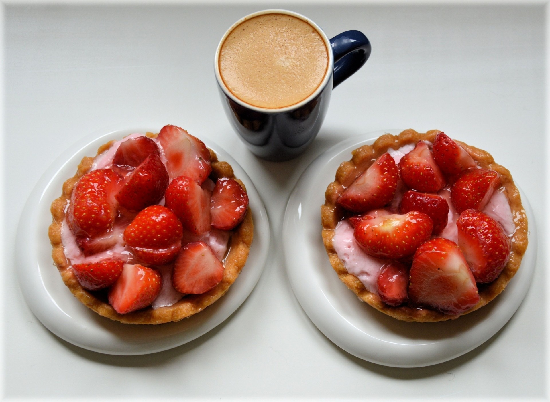 strawberries and black ceramic mug with coffee inside