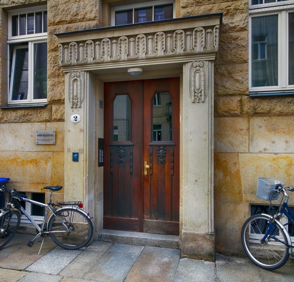 brown wooden panel door between two bicycles preview