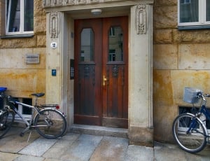 brown wooden panel door between two bicycles thumbnail