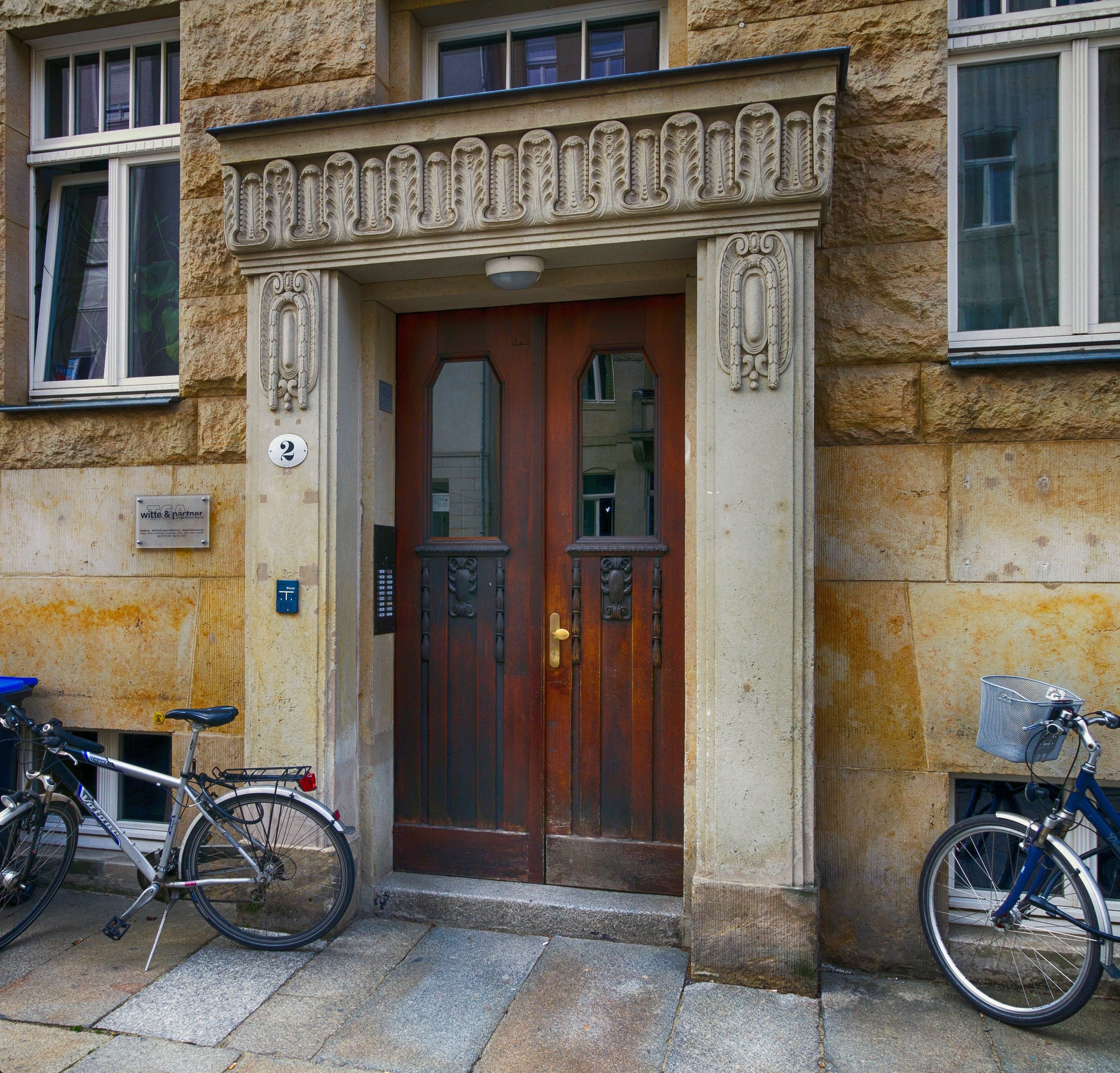 brown wooden panel door between two bicycles