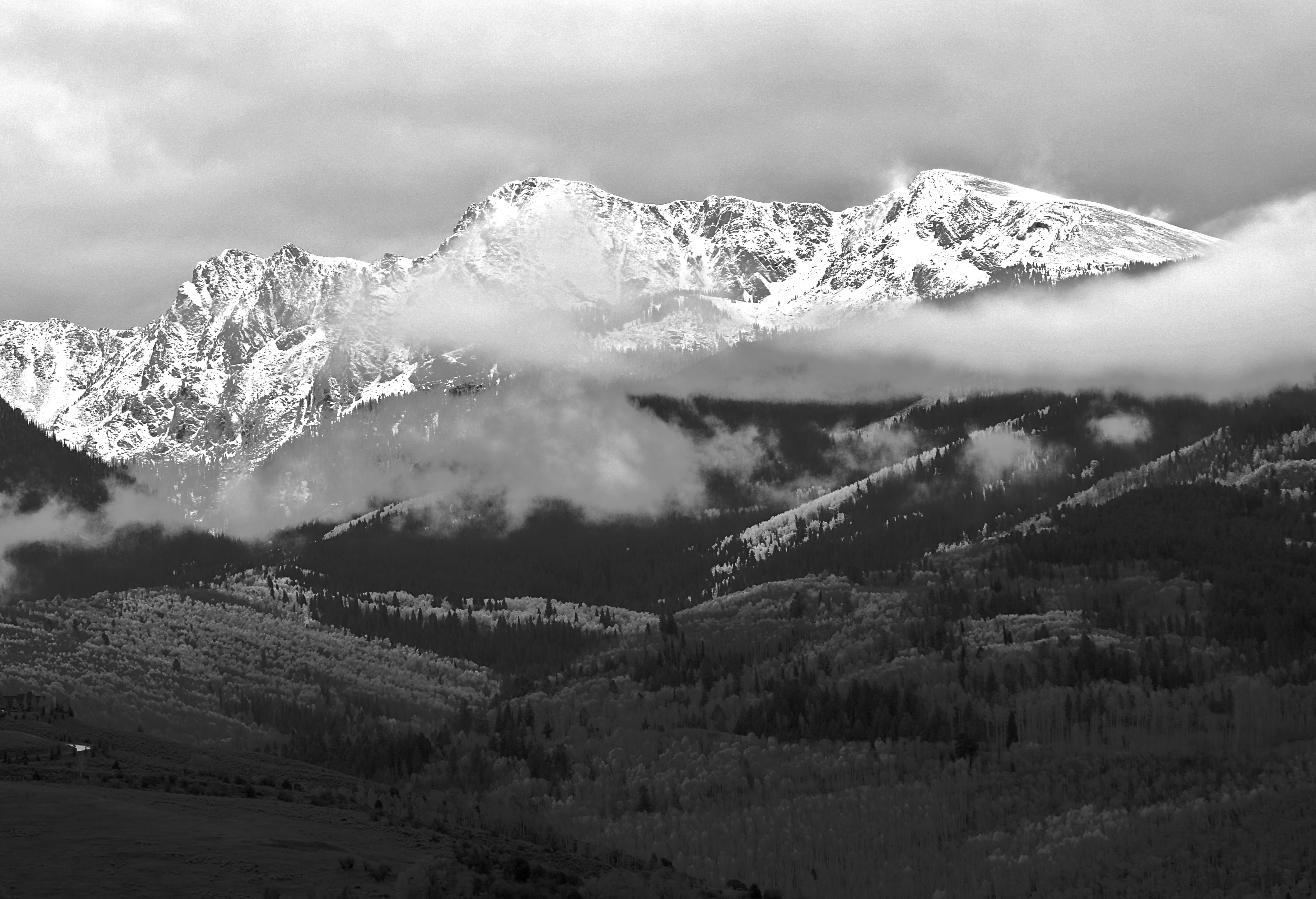 grayscale photograph of mountain alps with clouds