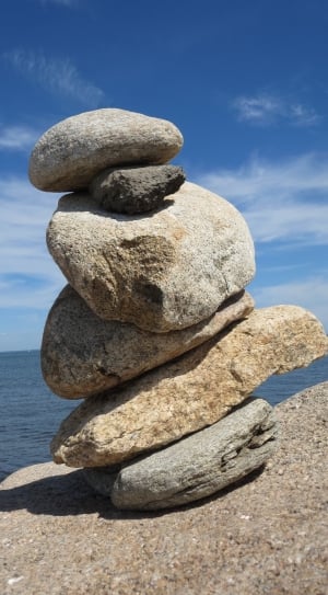 piled gray stones near body of water thumbnail