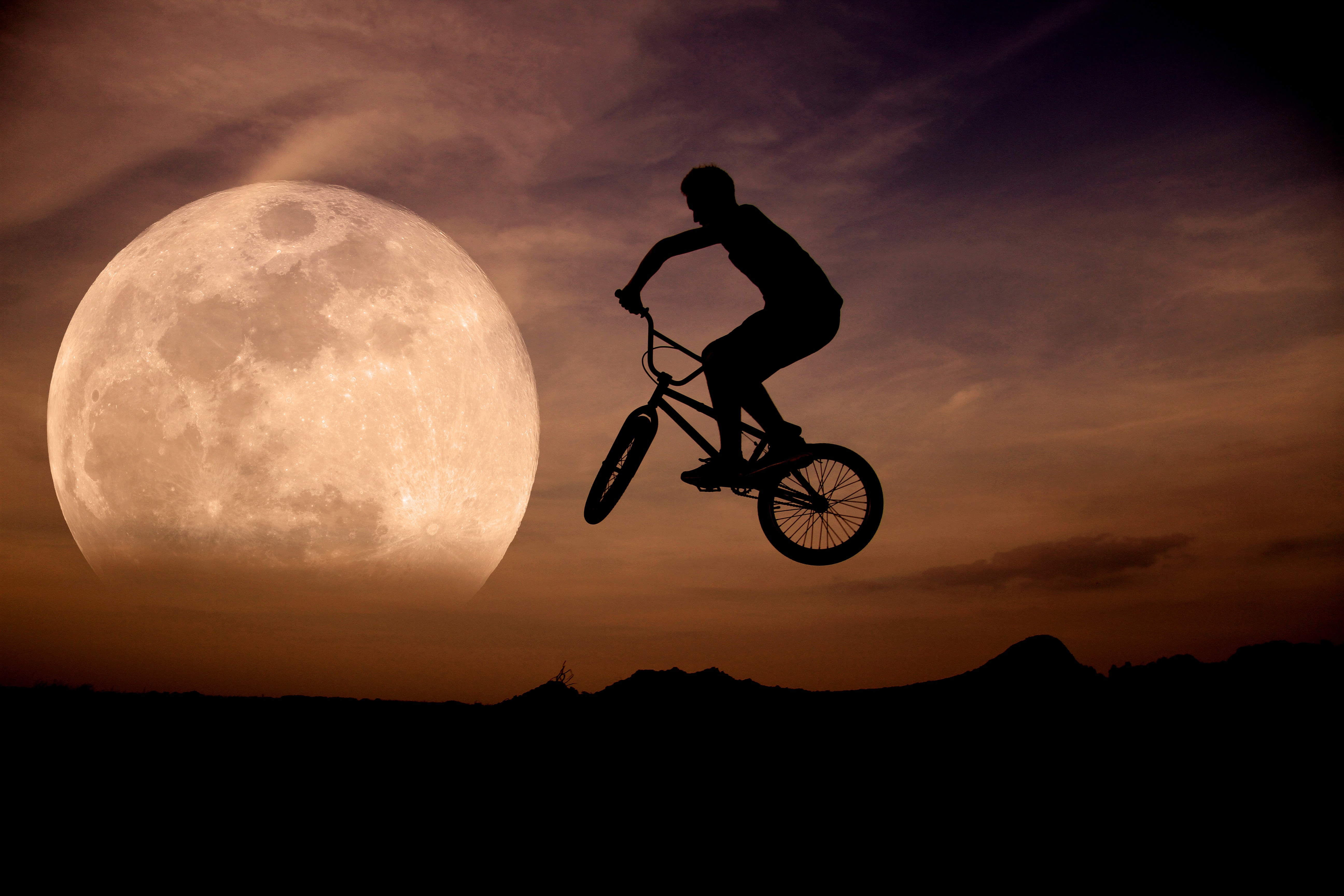 silhouette of man riding on bike