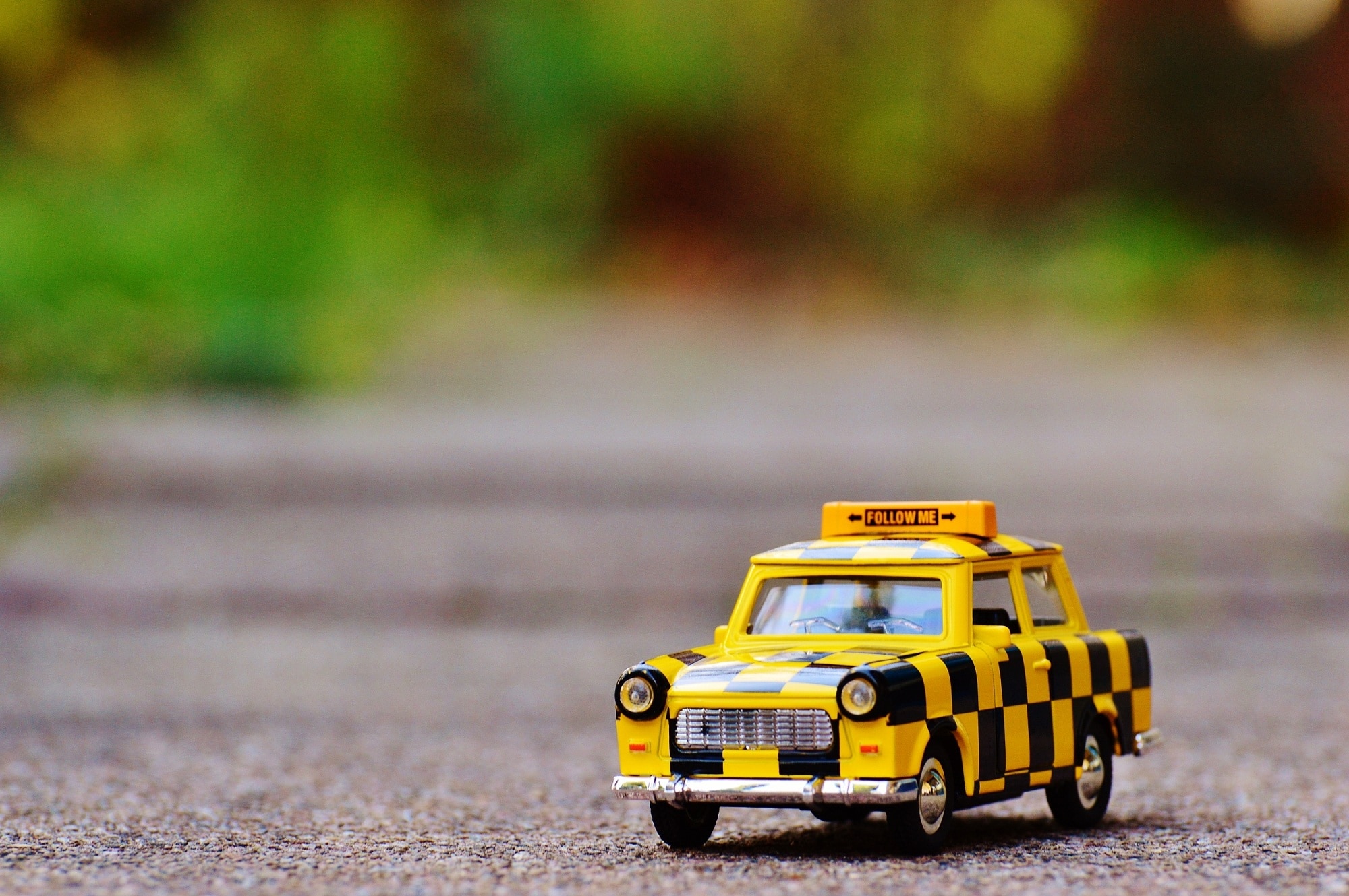 yellow and black taxi car toy on floor