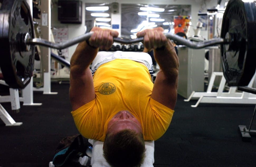 man in yellow lifting barbell preview